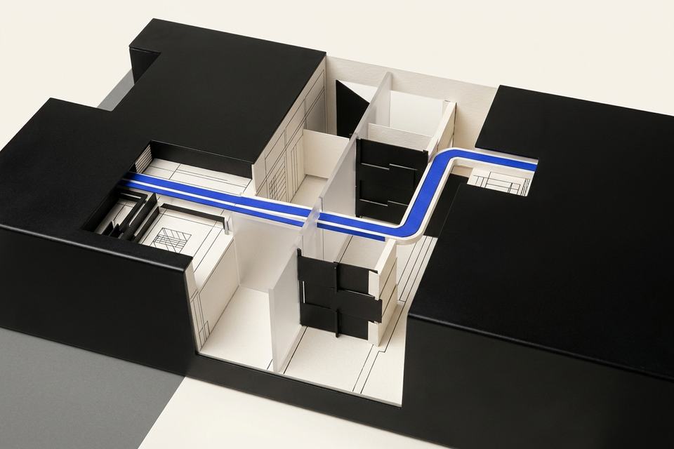 A cutaway architectural model shows one blue path moving through guarded black-and-bone chambers.